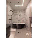 tub and shower in wetroom bath with mud-in ceiling lighting