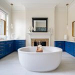 freestanding tub in bathroom with historic tiled fireplace