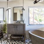 rustic primary bath with two vanities and freestanding tub