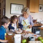 multi-generational kitchen with kids and older people making cookies