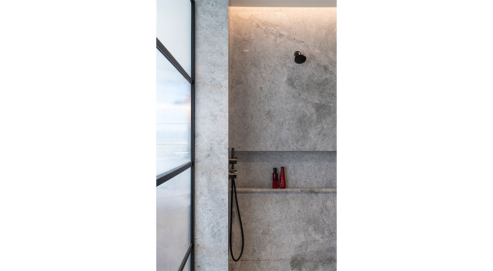 modern stone lined shower with glass door