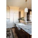 kitchen sink on island with marble counter in family kitchen