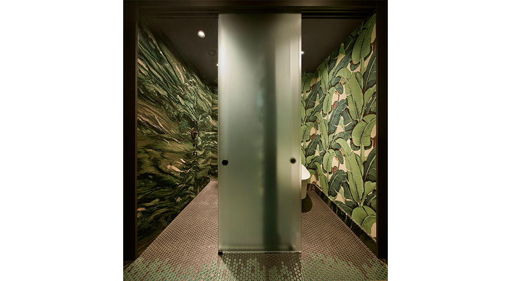 sliding glass door that encloses toilet and shower in green bathroom