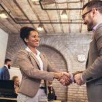 a man and woman shaking hands in demonstration of trust