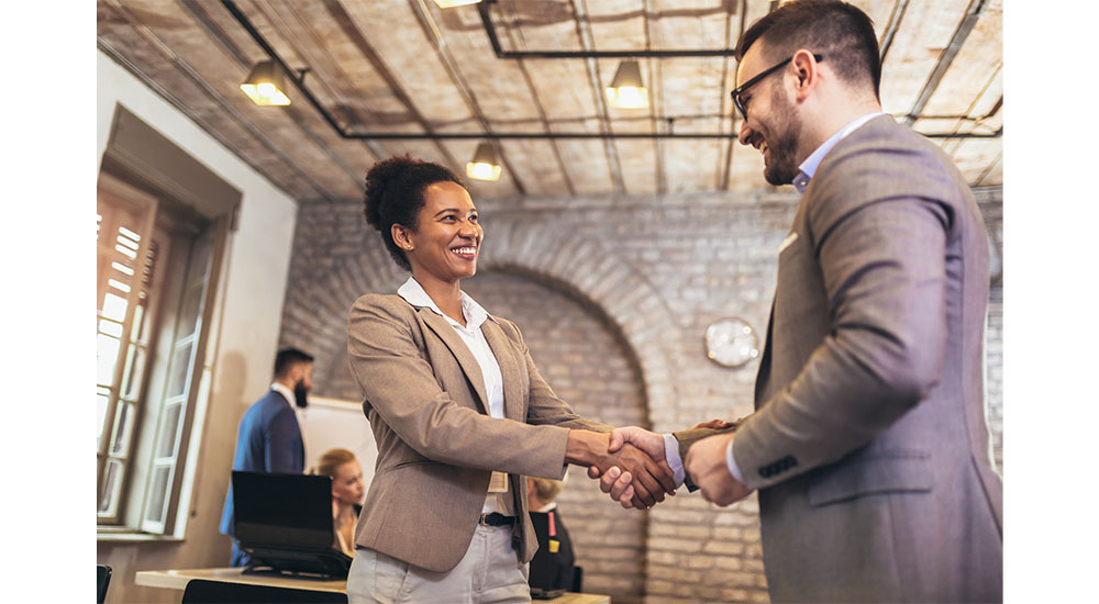 a man and woman shaking hands in demonstration of trust