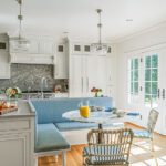 white kitchen with blue banquette in center of room in a classic home