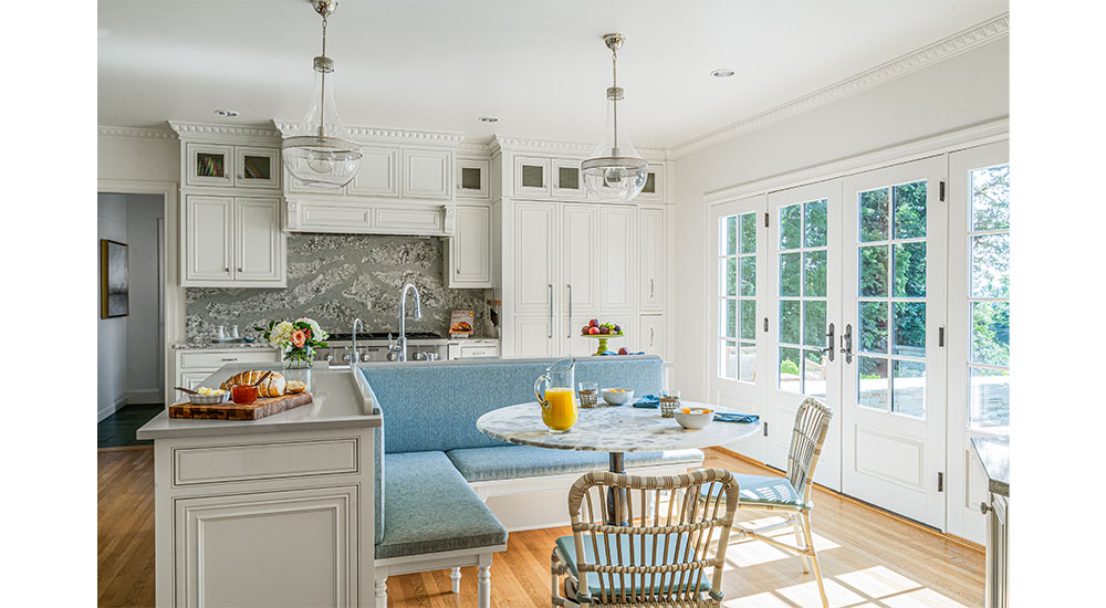 white kitchen with blue banquette in center of room in a classic home