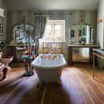 bathtub in middle of room with leather sofa and fireplace